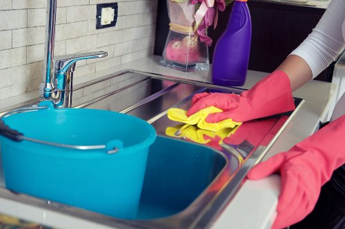 Kitchen surfaces and cupboards being cleaned before move in at a Tockwell home